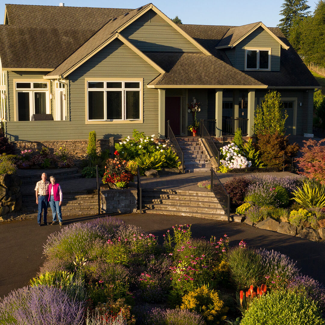 A couple standing in front of a home.