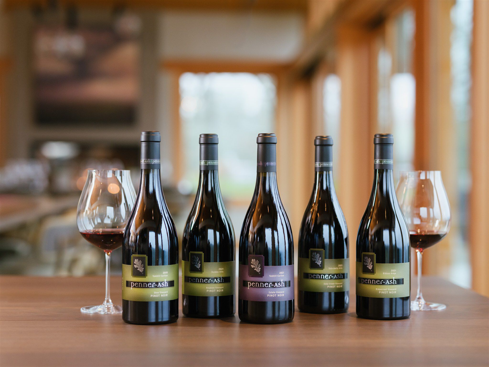 Five bottles of Penner-Ash wine standing on a table in the Pavilion.